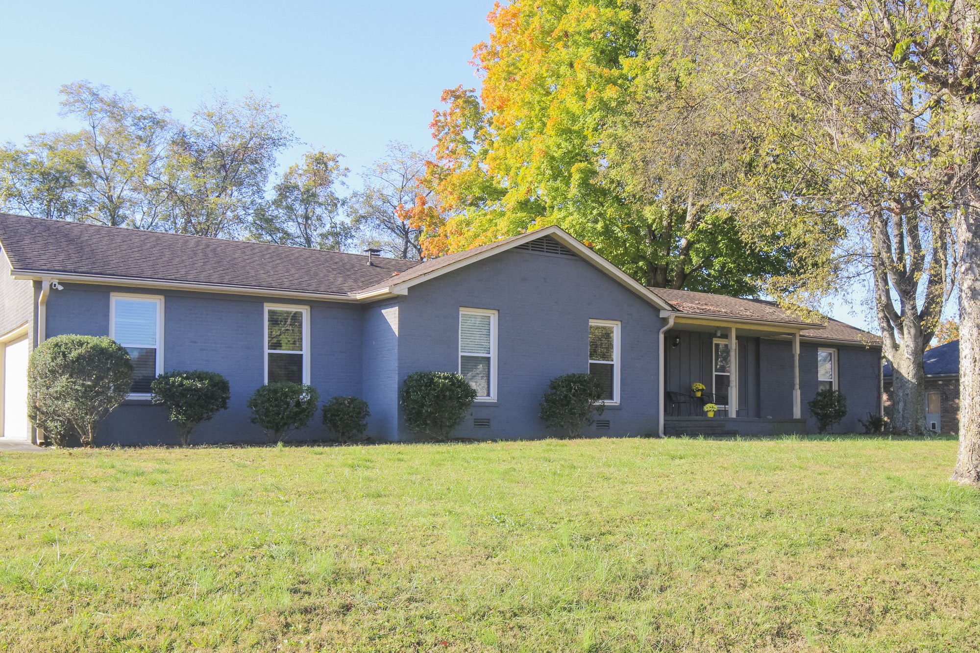 a front view of house with yard and trees in the background