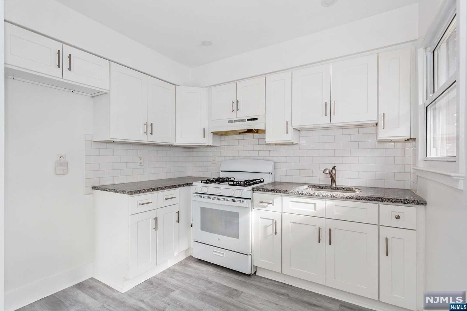 a kitchen with granite countertop white cabinets and white appliances