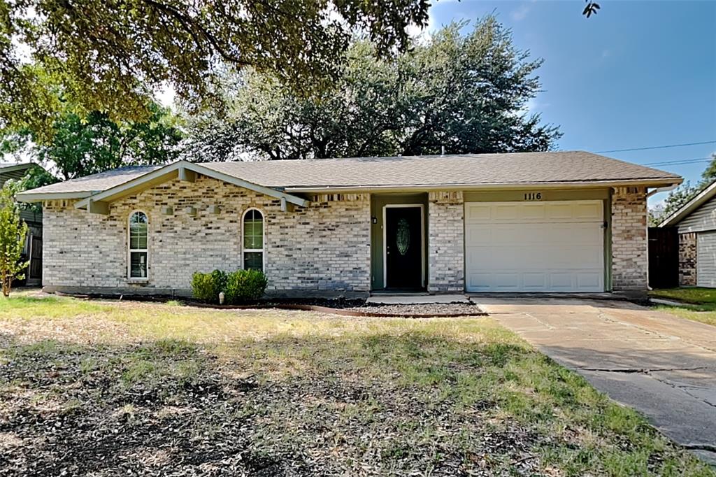 a front view of house with yard and trees in the background