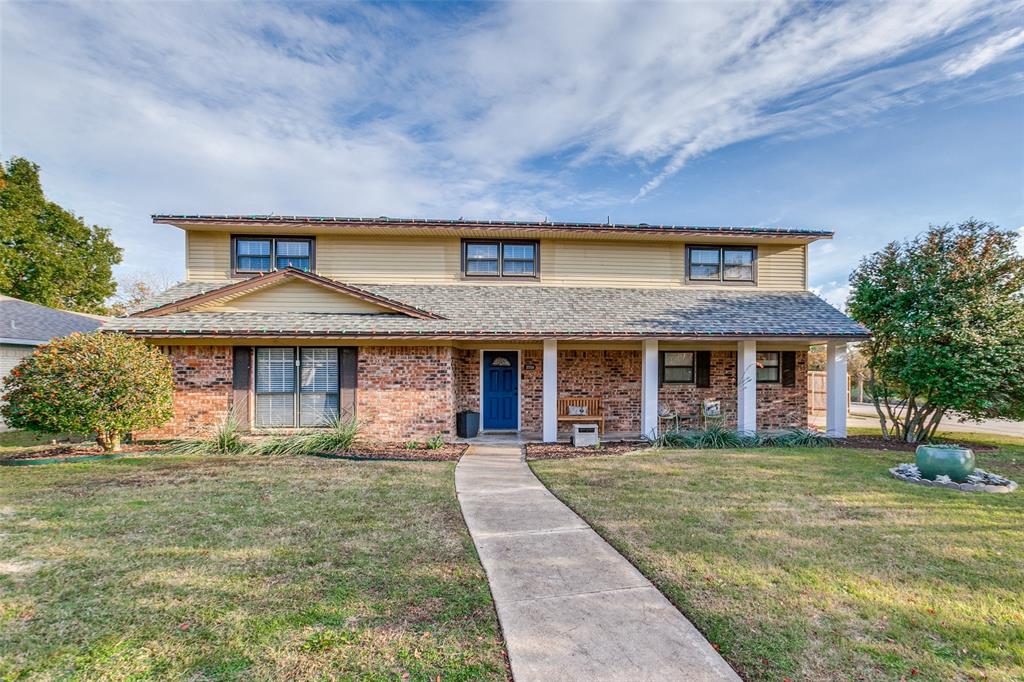 front view of a brick house with a yard