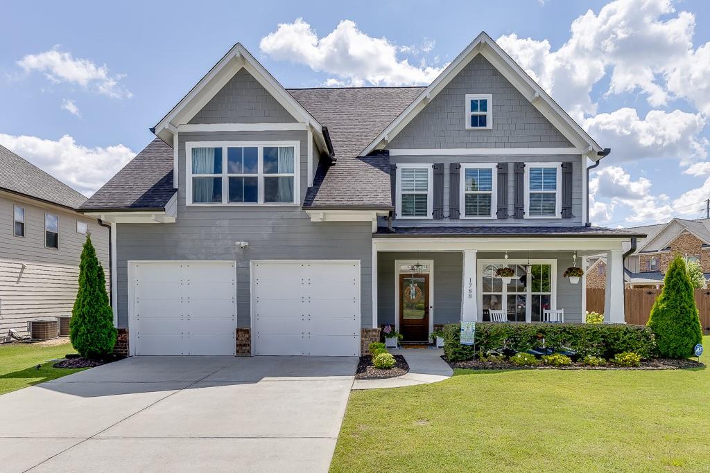 a front view of a house with yard and green space