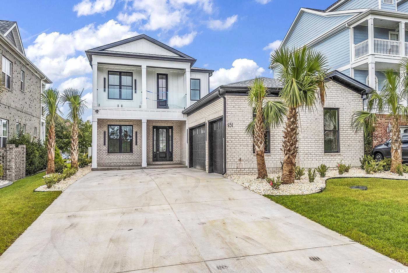 View of front of house with a balcony, a garage, a