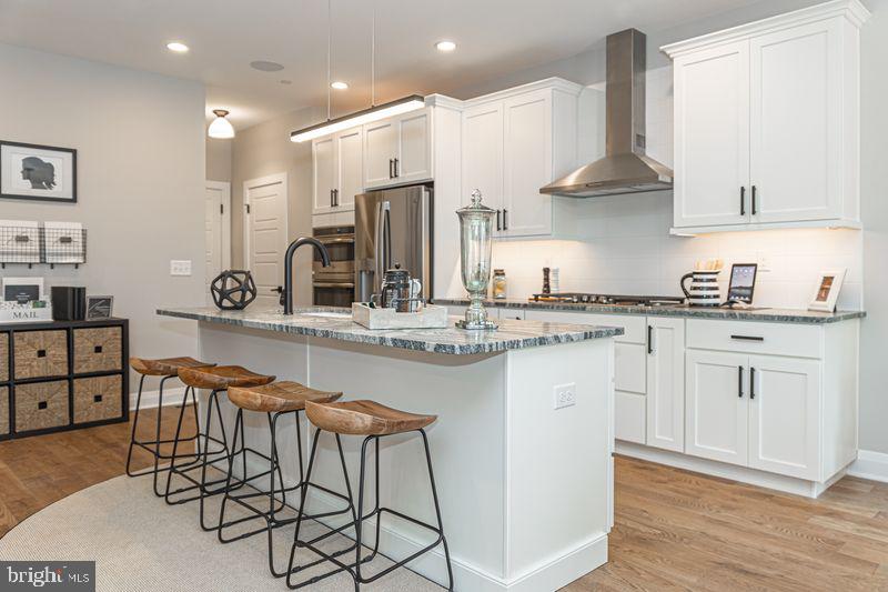 a kitchen with stainless steel appliances a sink a stove a refrigerator and cabinets