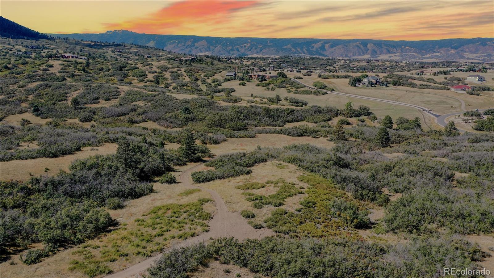 a view of a field with mountains in the background