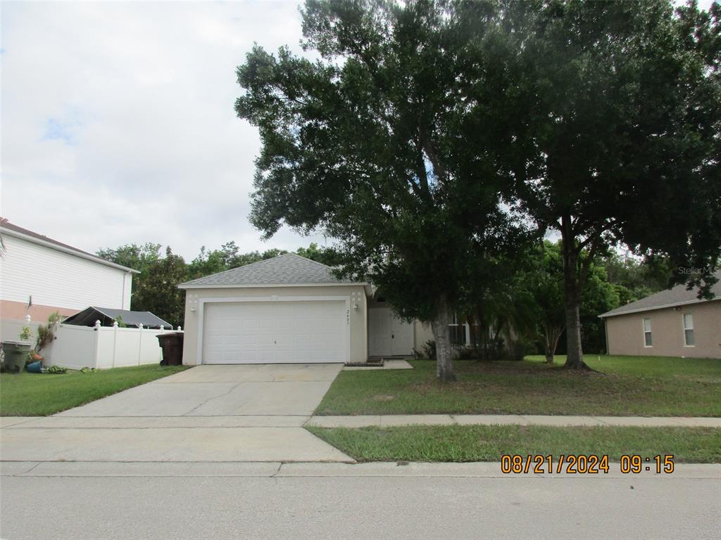 a front view of a house with a yard and a garage