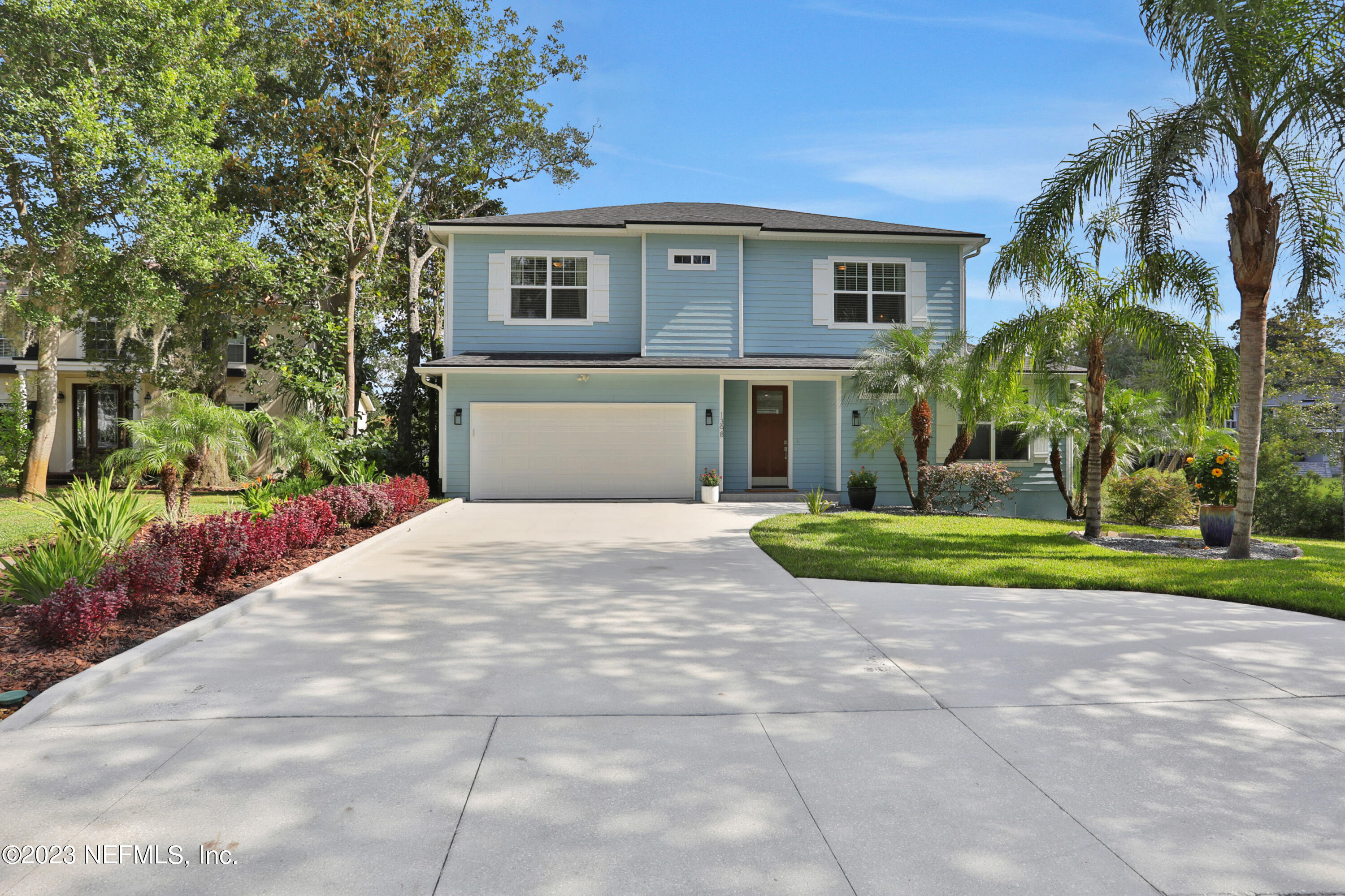 a front view of a house with a yard and trees