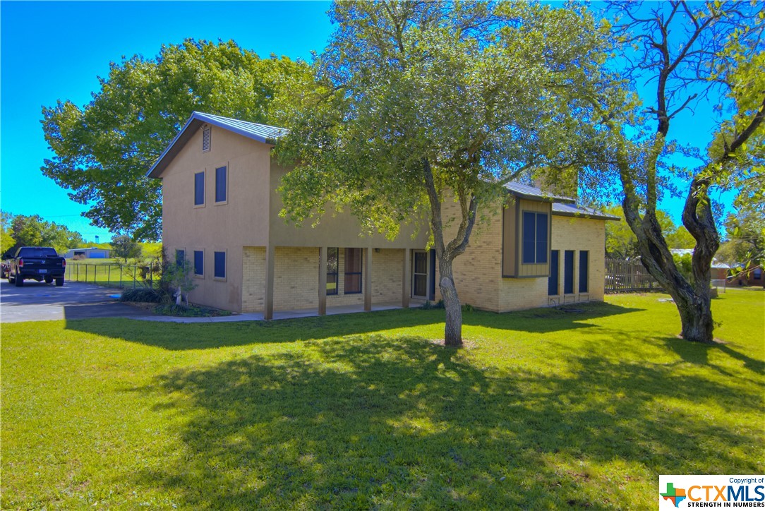 a view of a house with pool and a yard