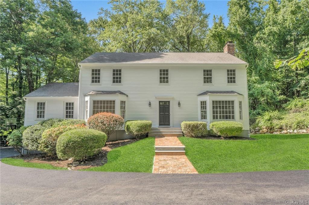 a front view of a house with a garden and yard