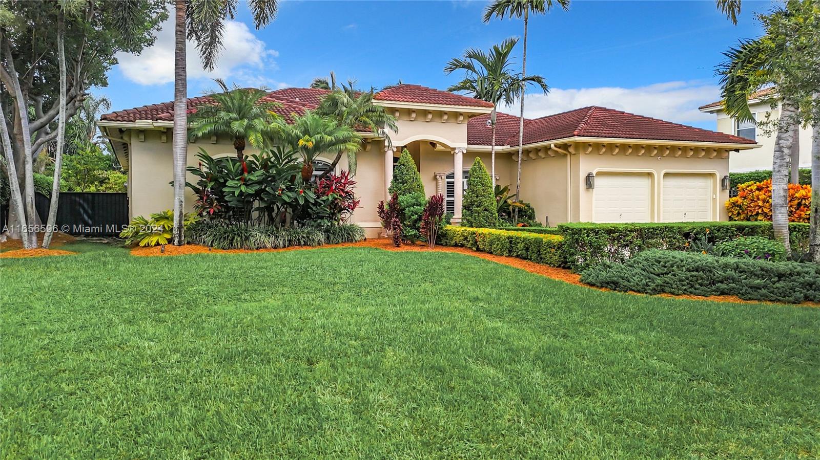 a front view of a house with a yard and potted plants