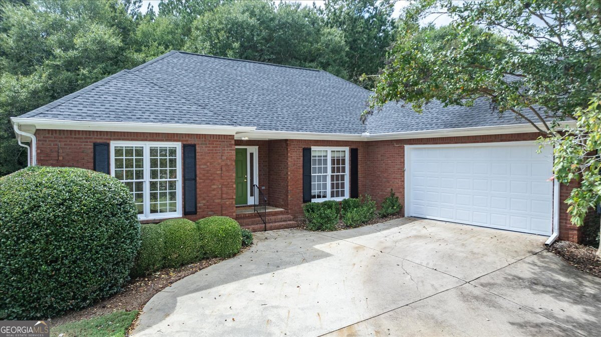 a front view of house with yard and trees around