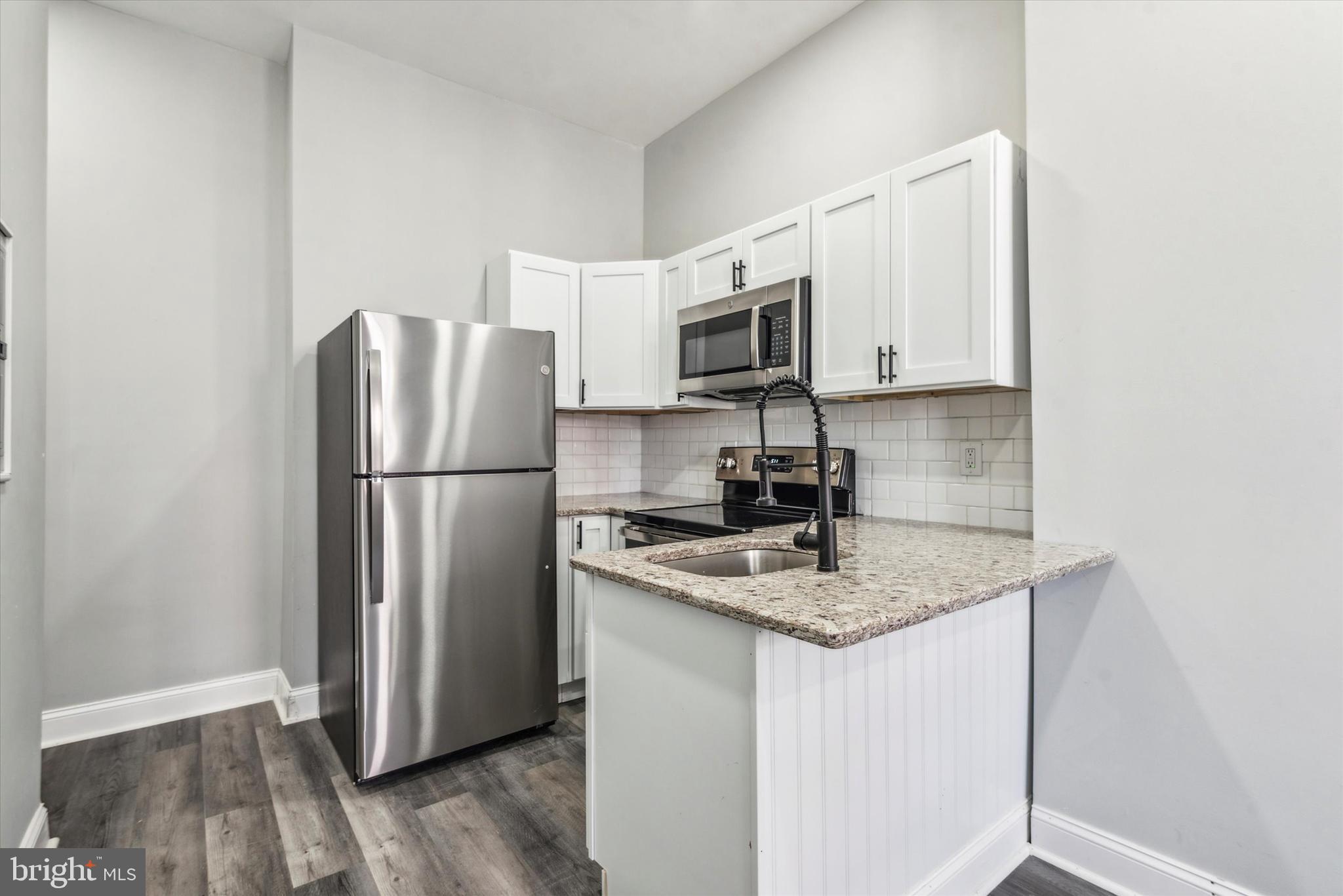 a kitchen with appliances a refrigerator and a sink