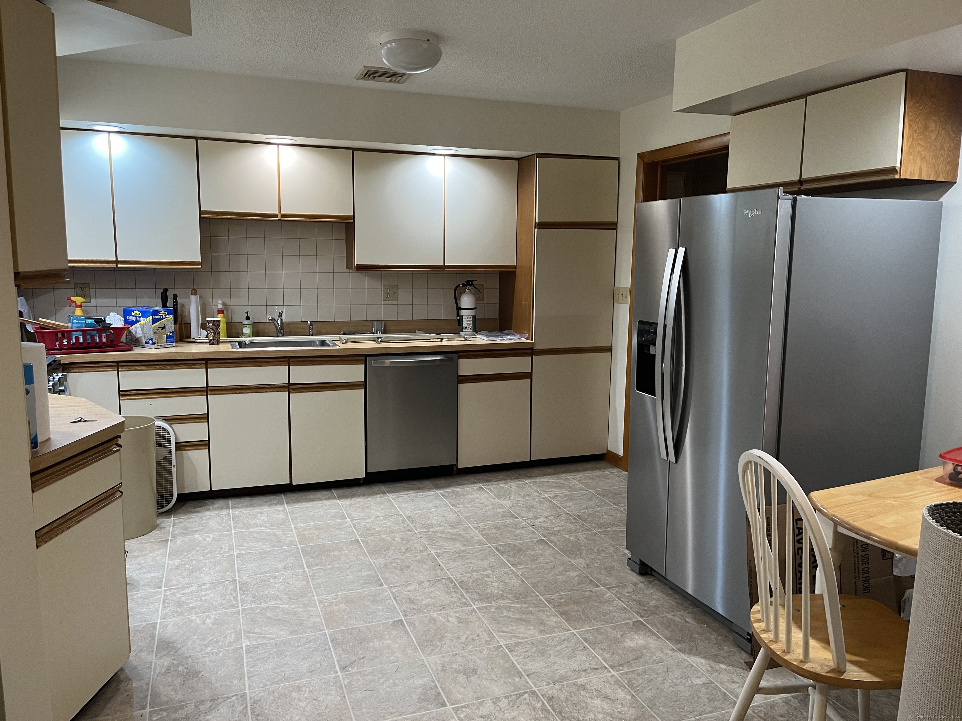 a kitchen with stainless steel appliances granite countertop a refrigerator a sink dishwasher a stove top oven a sink and dishwasher
