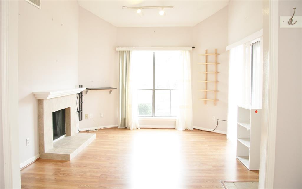 a view of an empty room with a fireplace and a window