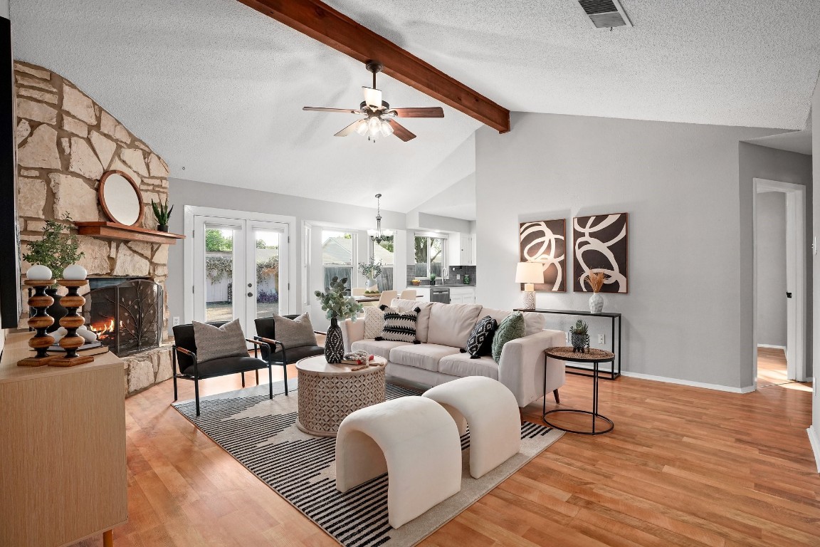 The spacious living room features a vaulted and beamed ceiling, creating an airy and open atmosphere.