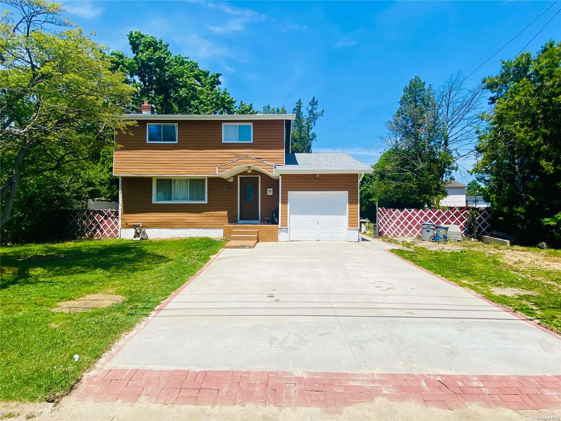 a front view of a house with a yard and trees