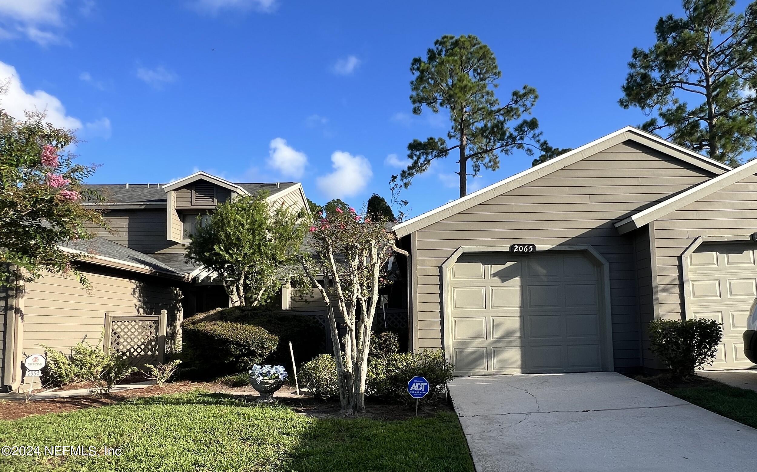 a view of a house with a yard and a garage