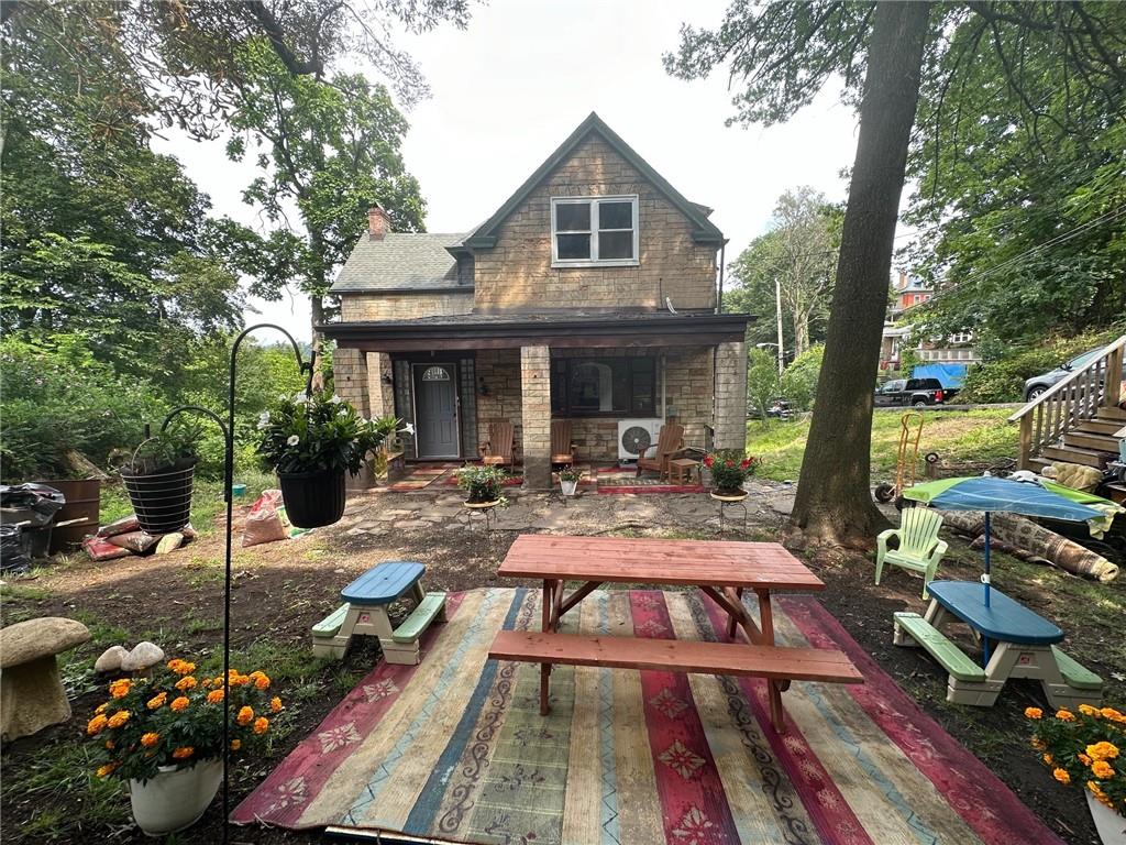 a view of a patio with table and chairs potted plants and large tree