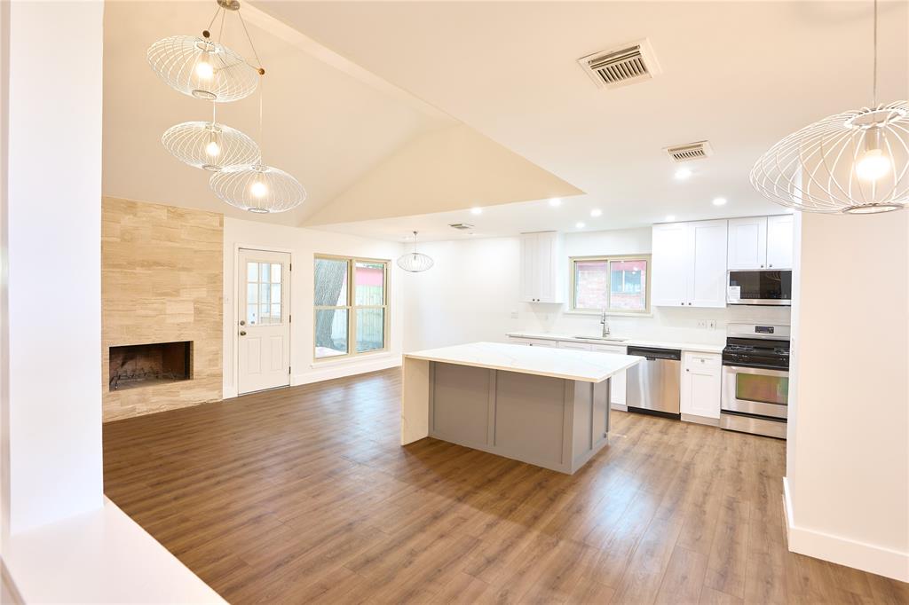 a large kitchen with cabinets wooden floor and stainless steel appliances