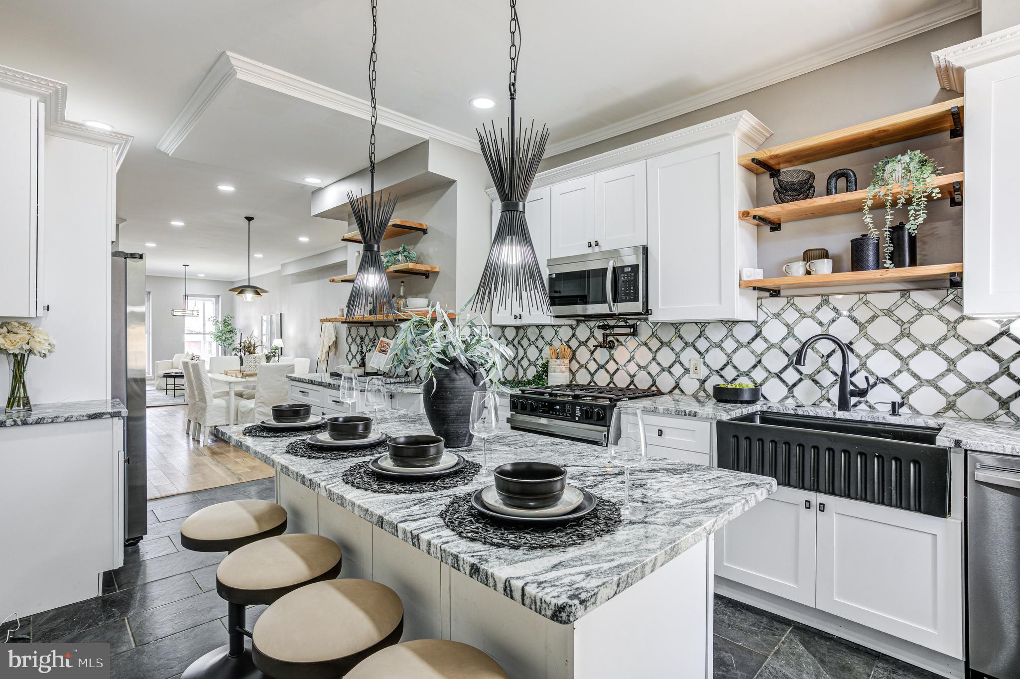 a kitchen with stainless steel appliances granite countertop a sink a stove a microwave and cabinets