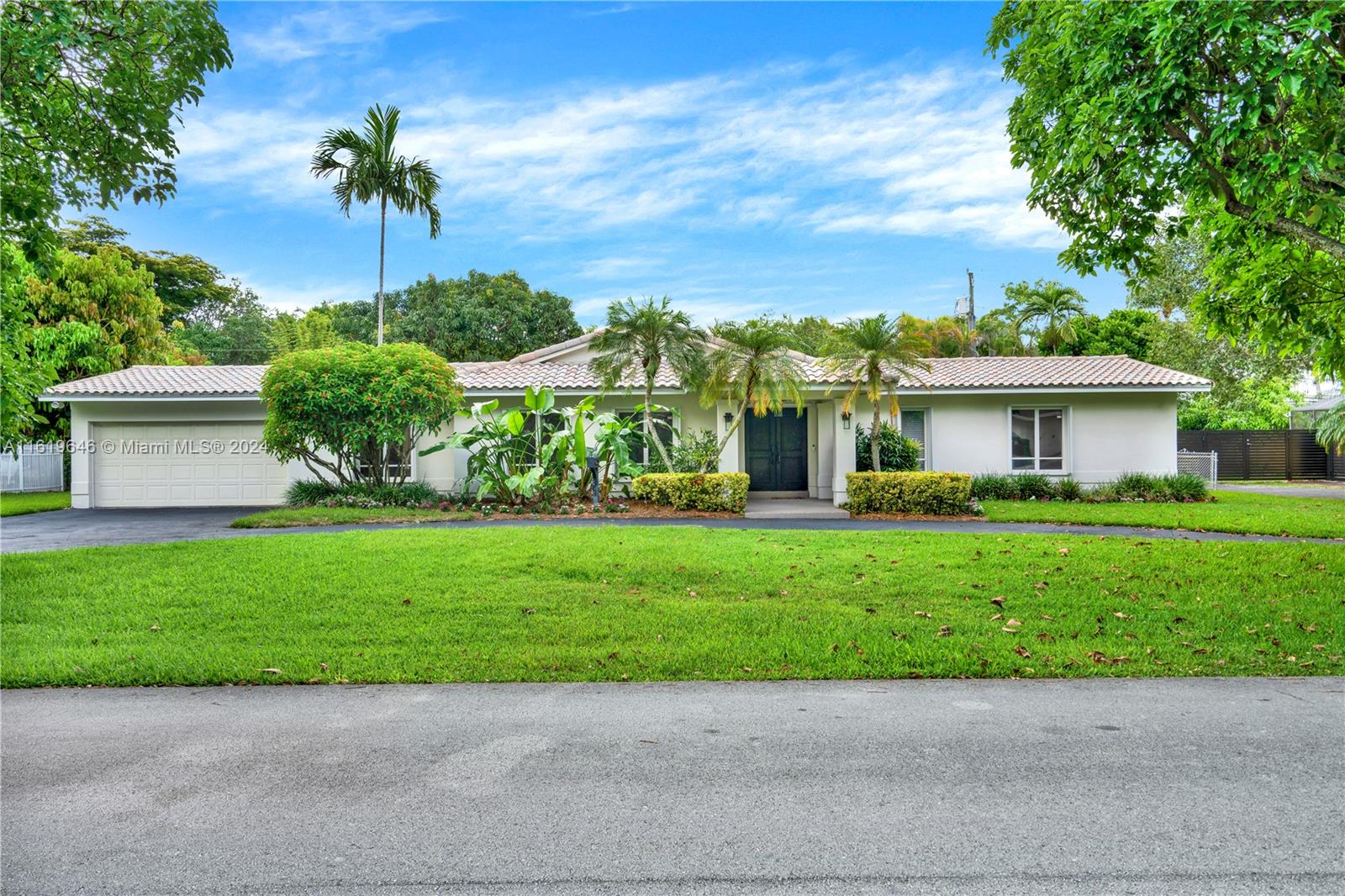 a front view of a house with a garden and yard