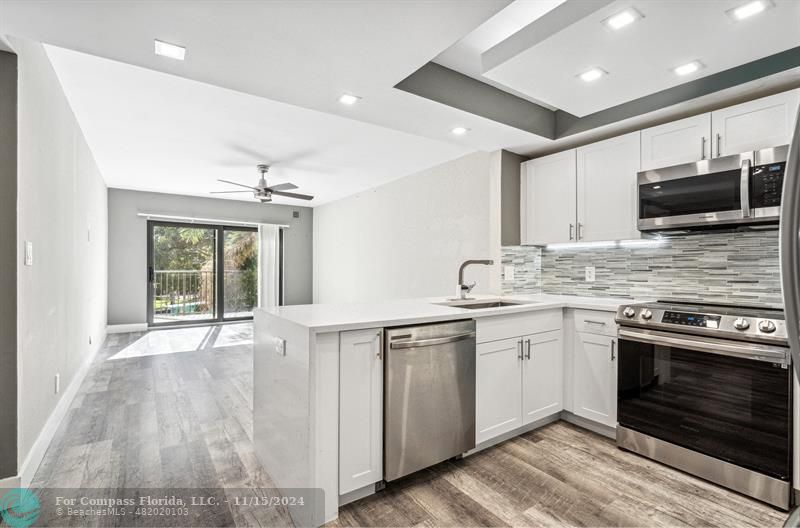 a large kitchen with stainless steel appliances granite countertop a stove and a sink