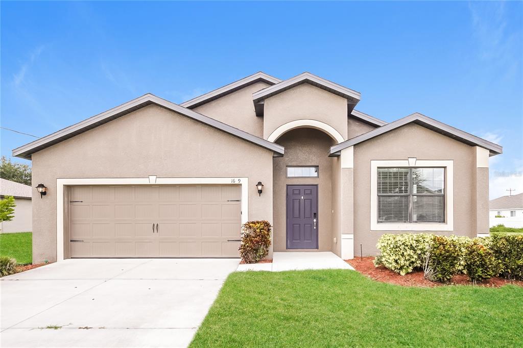 a front view of a house with a yard and garage