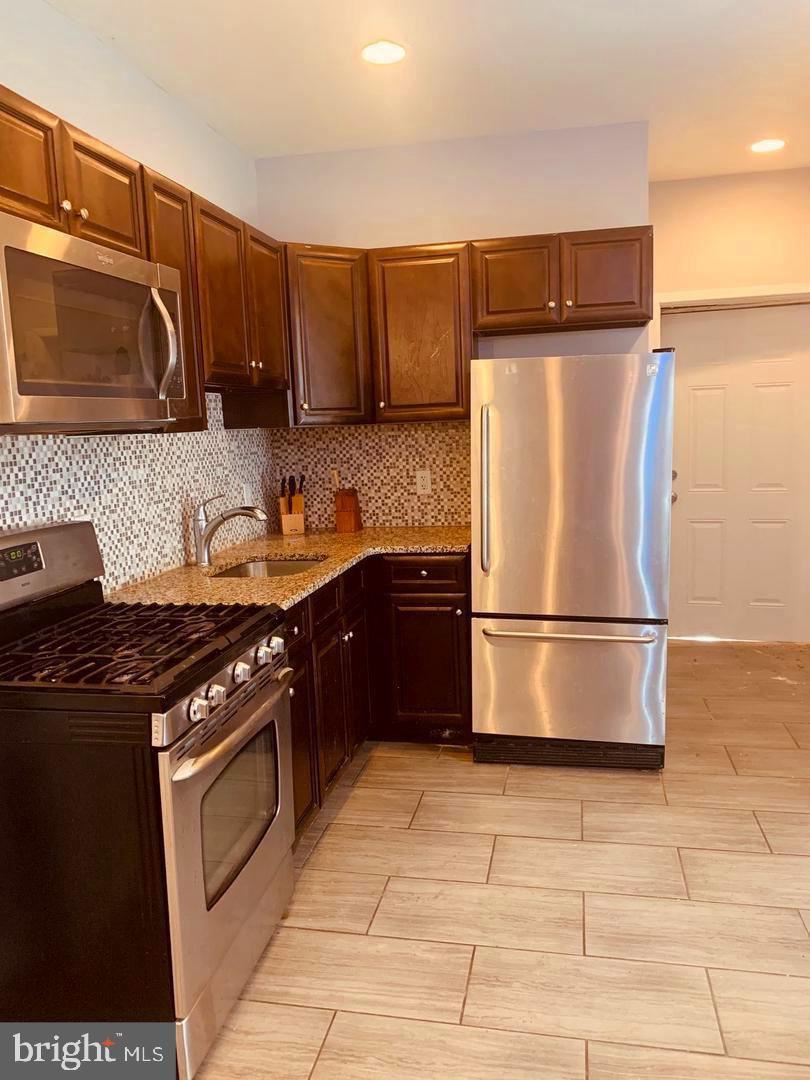 a kitchen with a refrigerator sink and stove