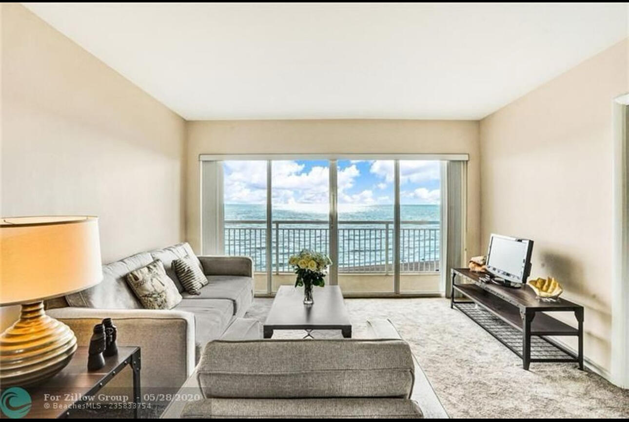 a living room with furniture and a floor to ceiling window