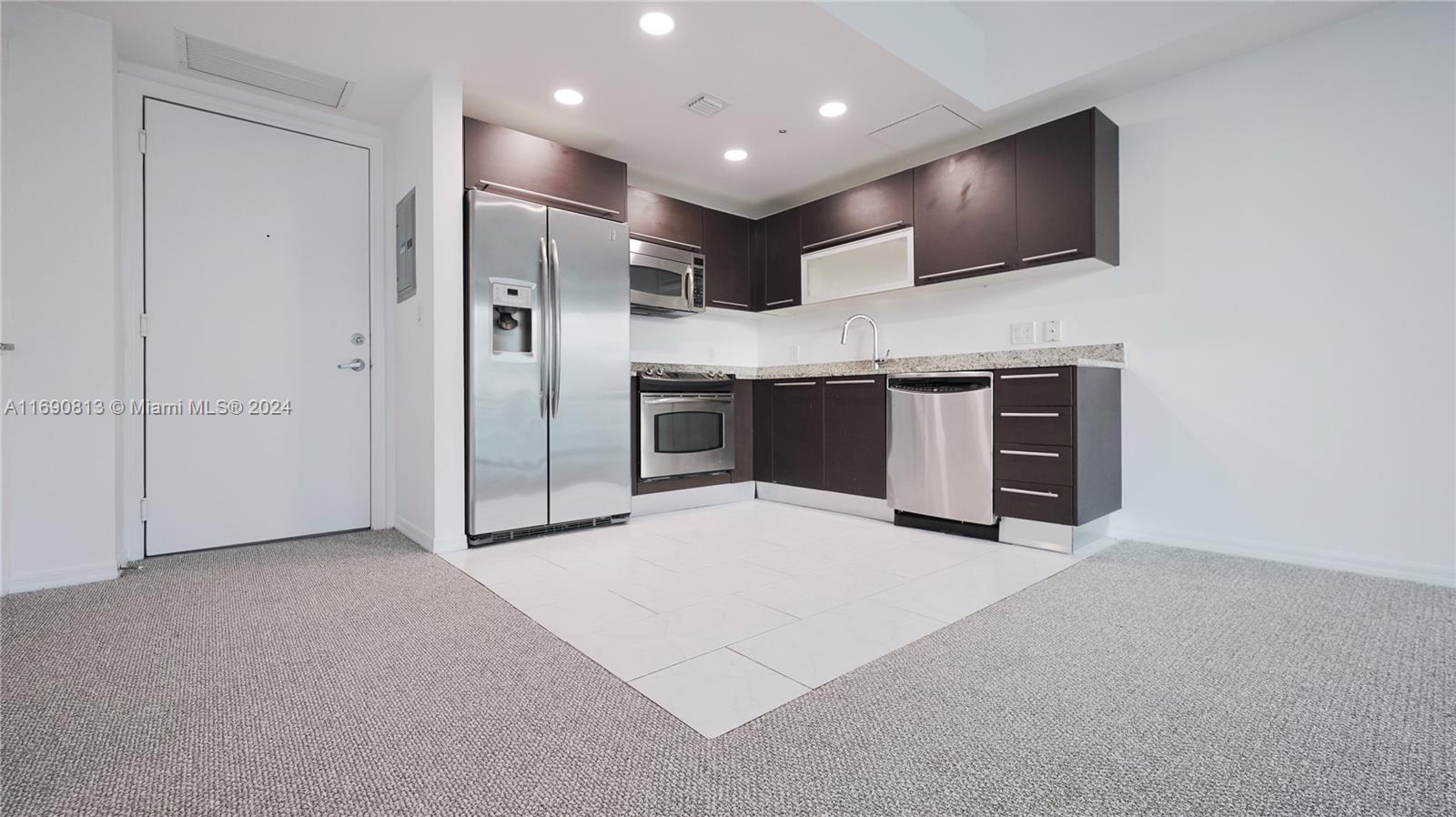 a view of a kitchen with a sink and a refrigerator