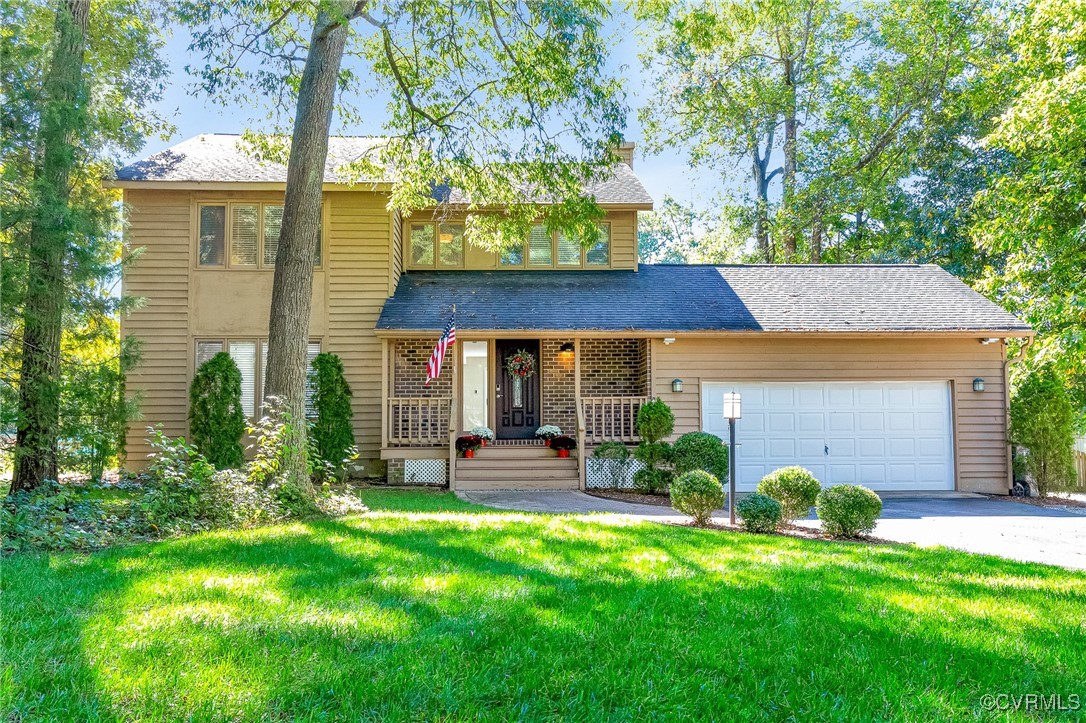 View of front of house with a front yard, a garage