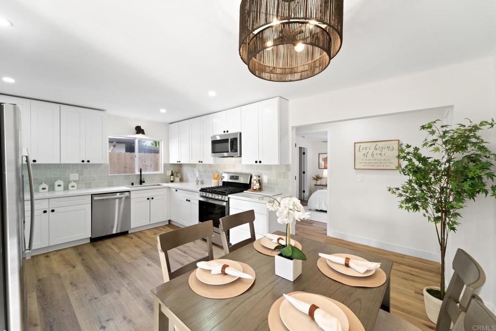 a open dining room with furniture a kitchen view and wooden floor