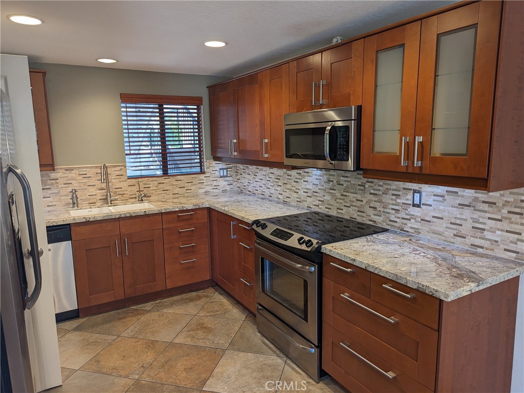 a kitchen with granite countertop stainless steel appliances a stove sink and microwave