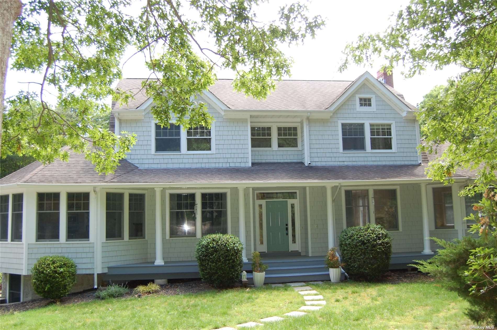 a front view of a house with yard and green space