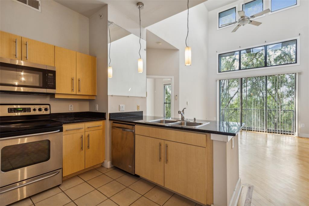 a kitchen with stainless steel appliances granite countertop a stove a sink and a microwave