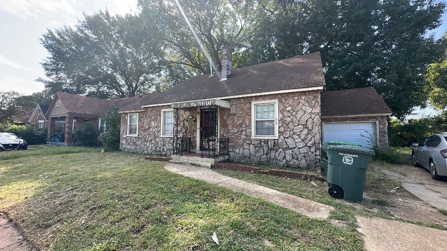 Ranch-style house featuring a front lawn and a garage