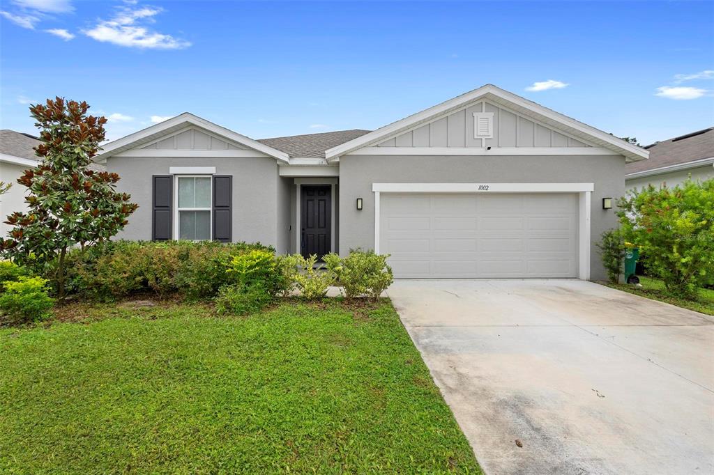 a front view of a house with a yard and garage