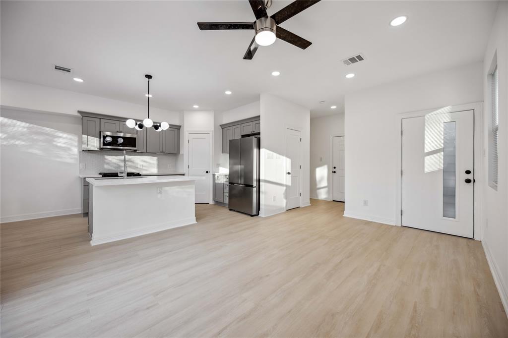 a view of kitchen with stainless steel appliances kitchen island a refrigerator and a stove top oven