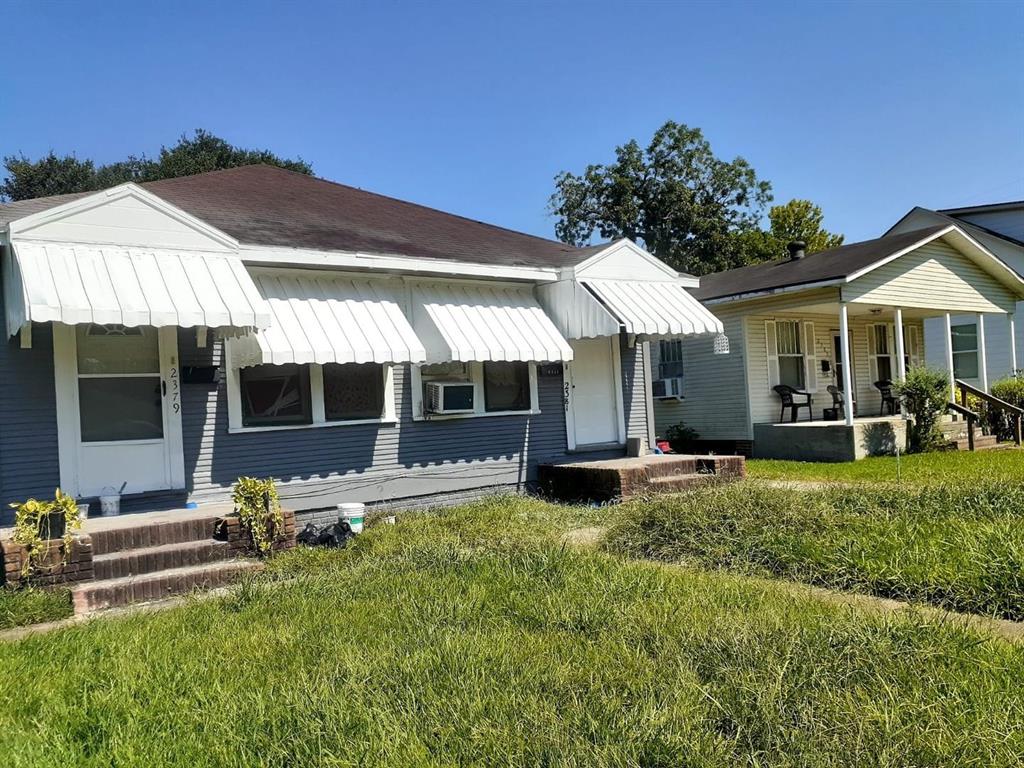 a view of a house with a yard and sitting area