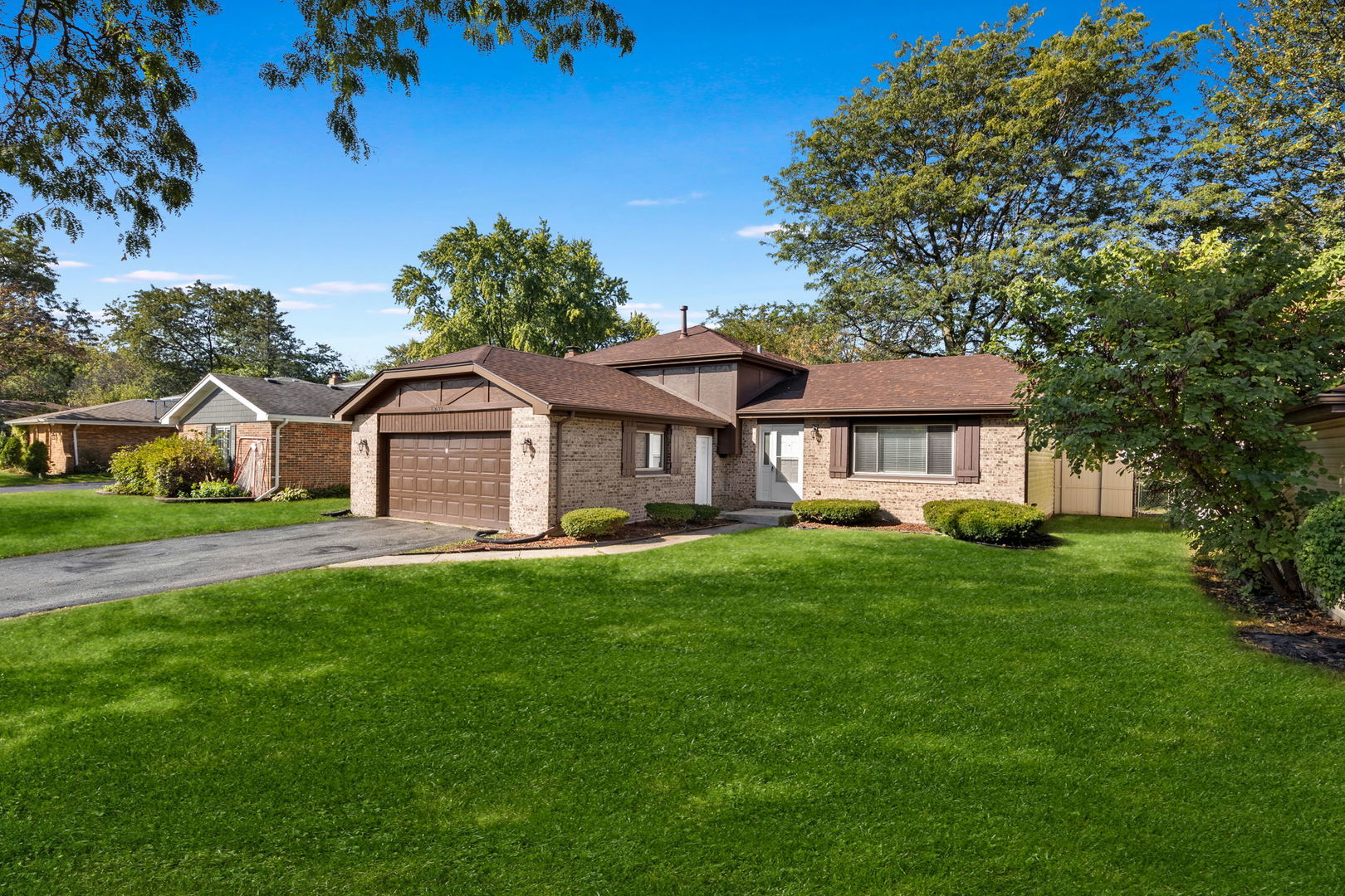 a front view of a house with yard and green space