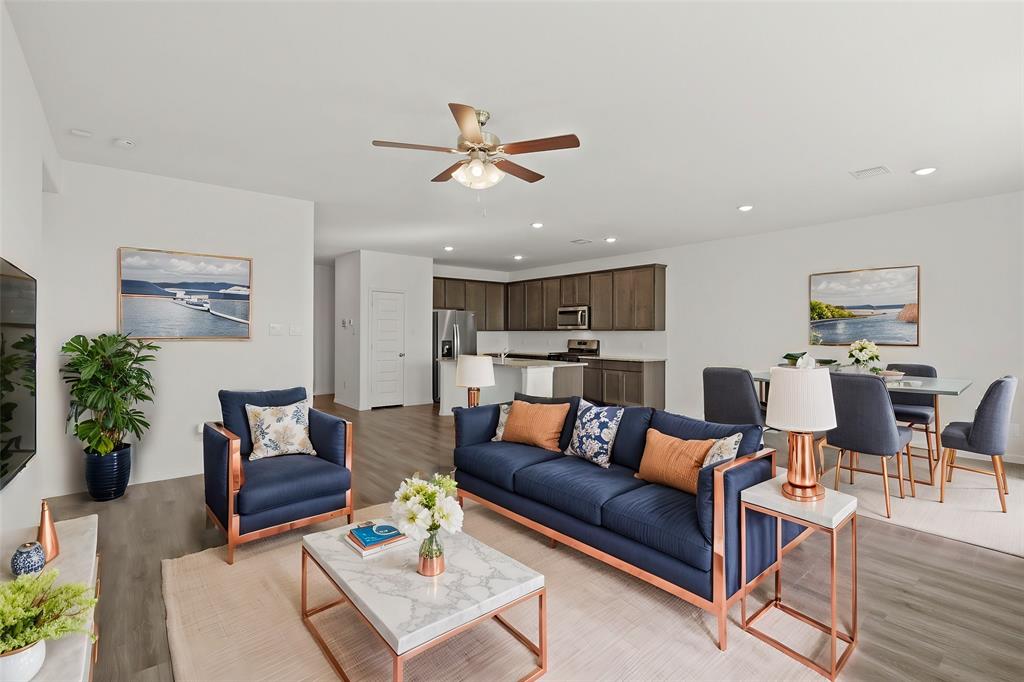 a living room with furniture kitchen view and a potted plant