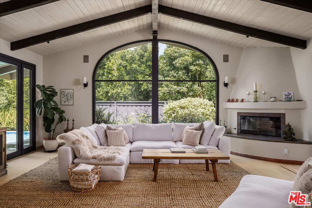 a living room with furniture fireplace and large windows