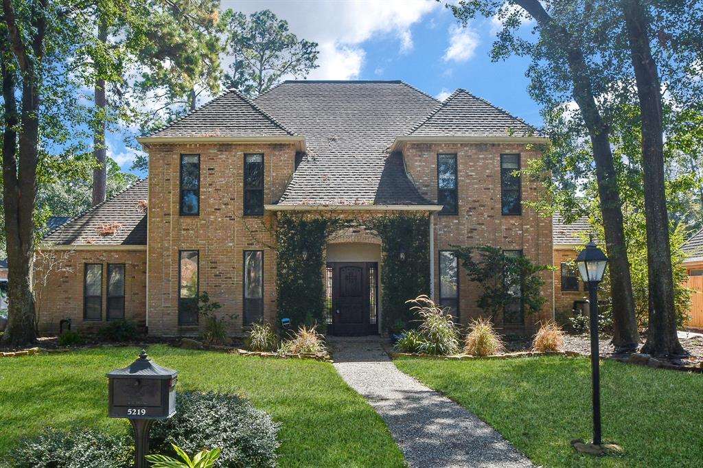 a front view of a house with a yard and trees