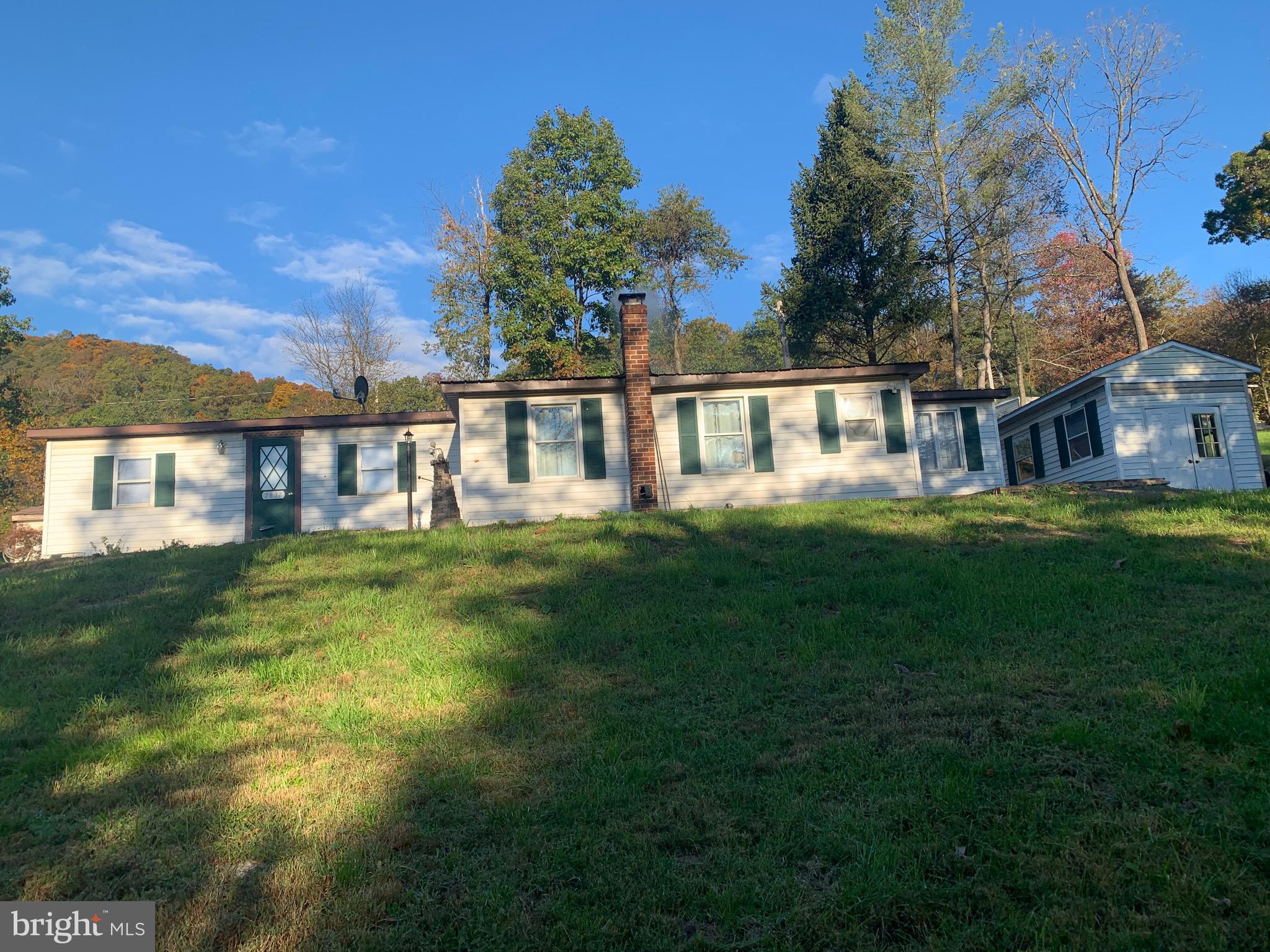 a view of a house with a big yard and large trees