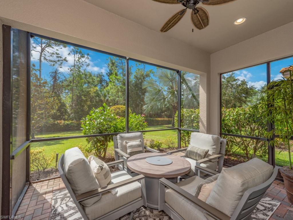 a living room with patio furniture and a floor to ceiling window