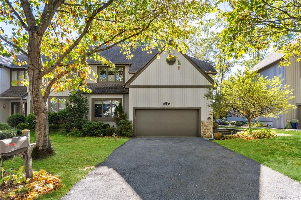 View of front of home with a front yard and a garage