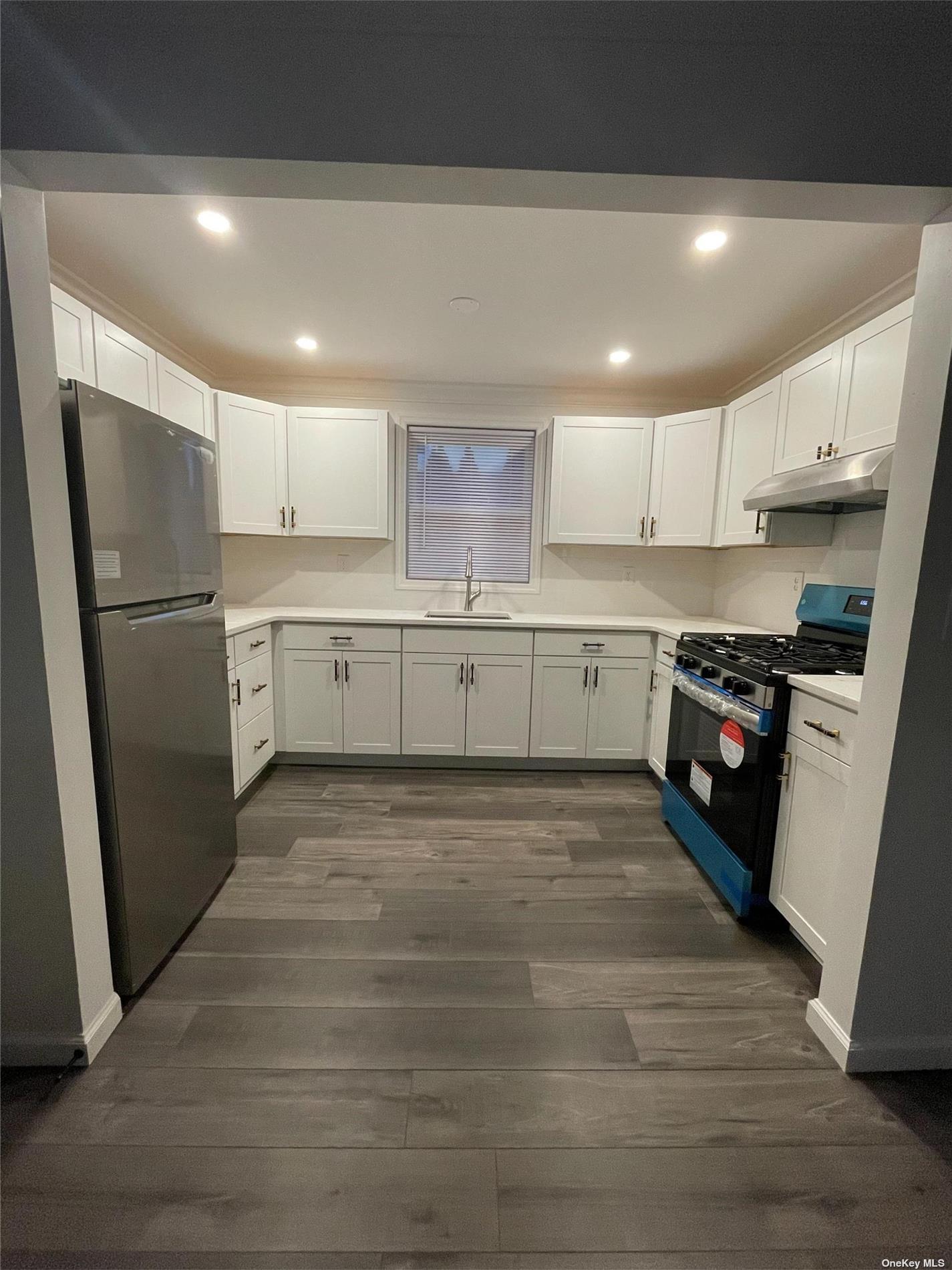 a kitchen with granite countertop a refrigerator and a sink