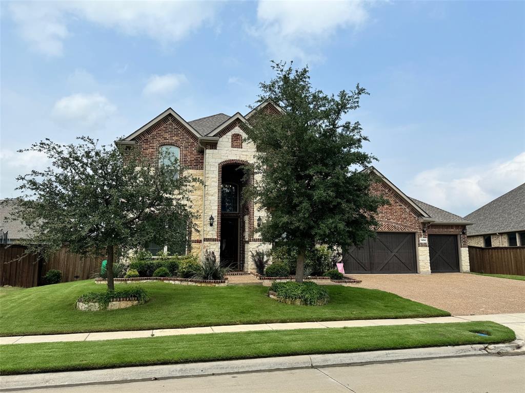 a front view of a house with a yard and potted plants