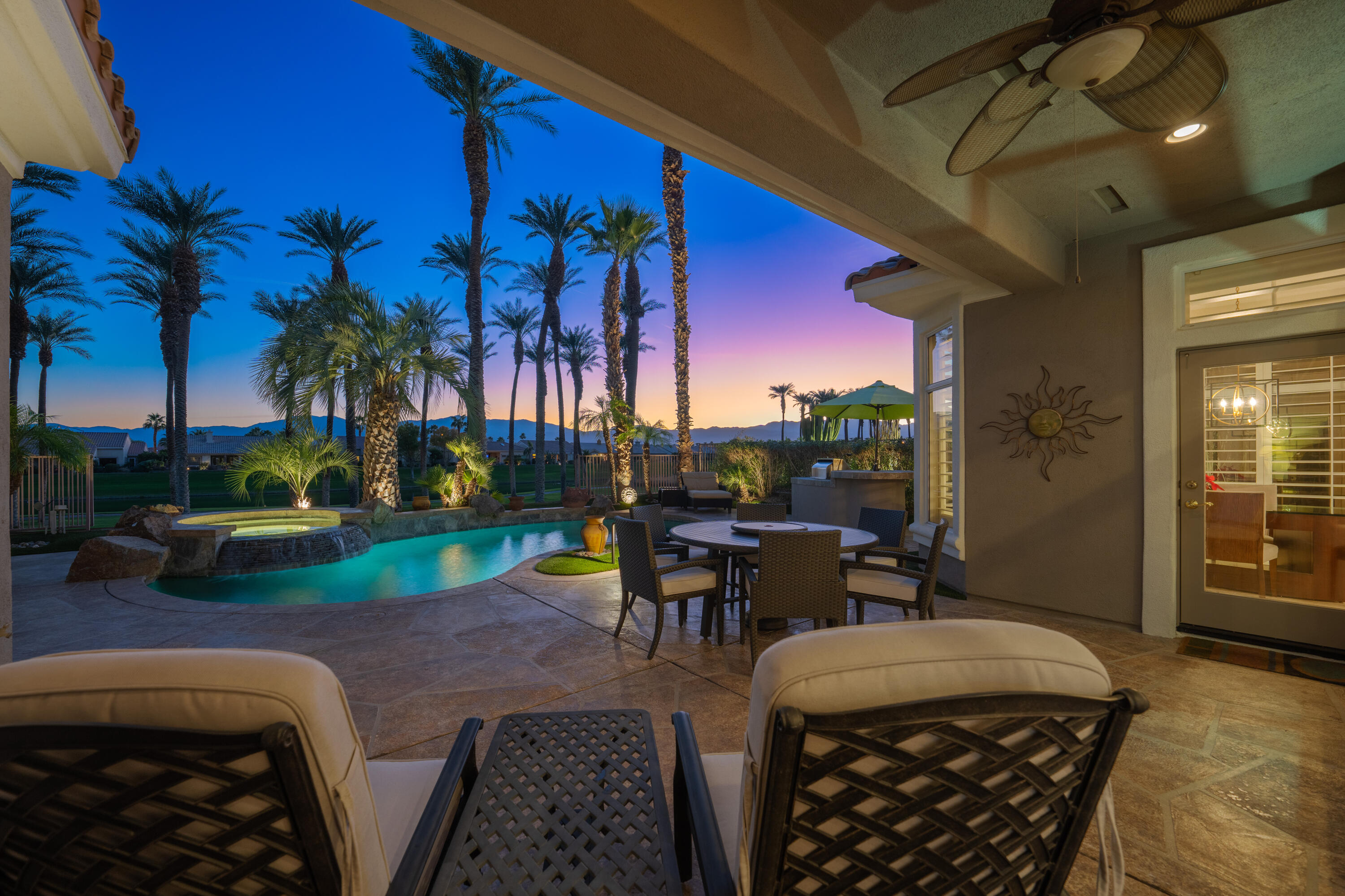 a view of a patio with table and chairs potted plants and palm trees