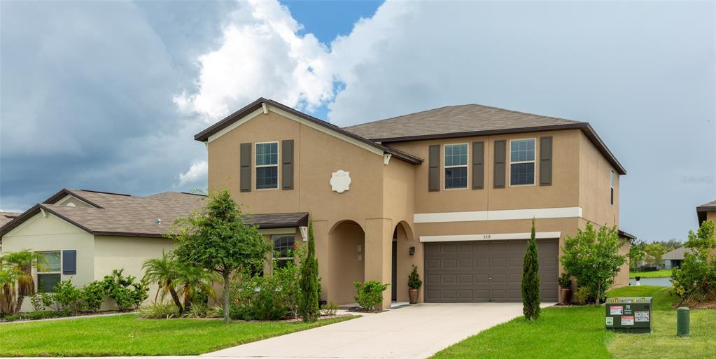 a front view of a house with a yard and garage