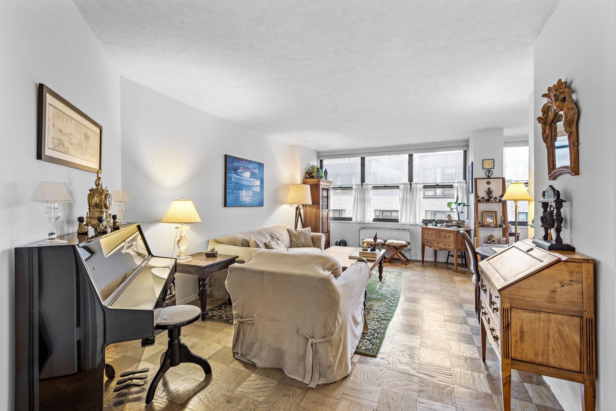 a living room with furniture a flat screen tv and large windows